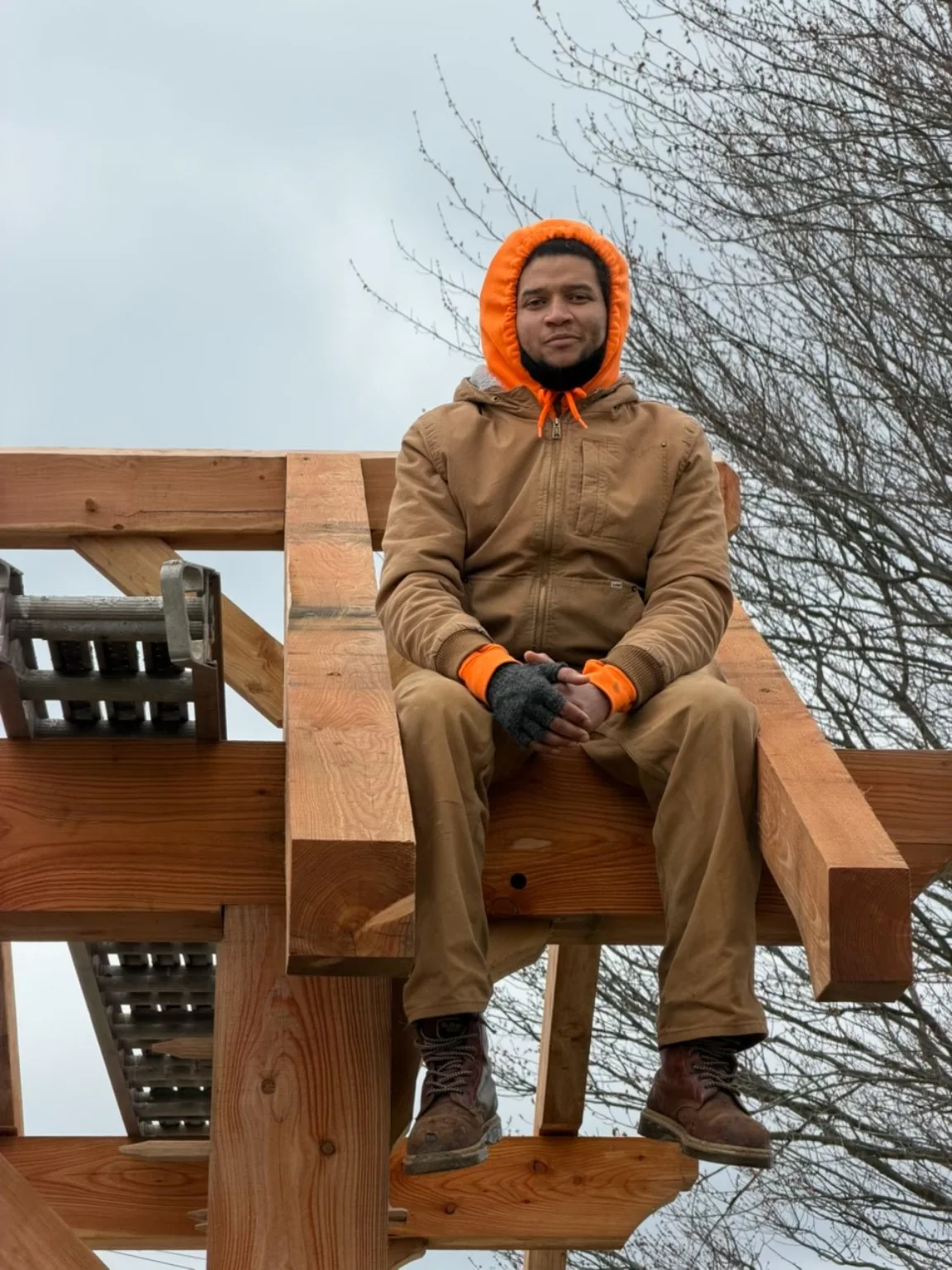 Dom seated on a traditional timber frame during construction
