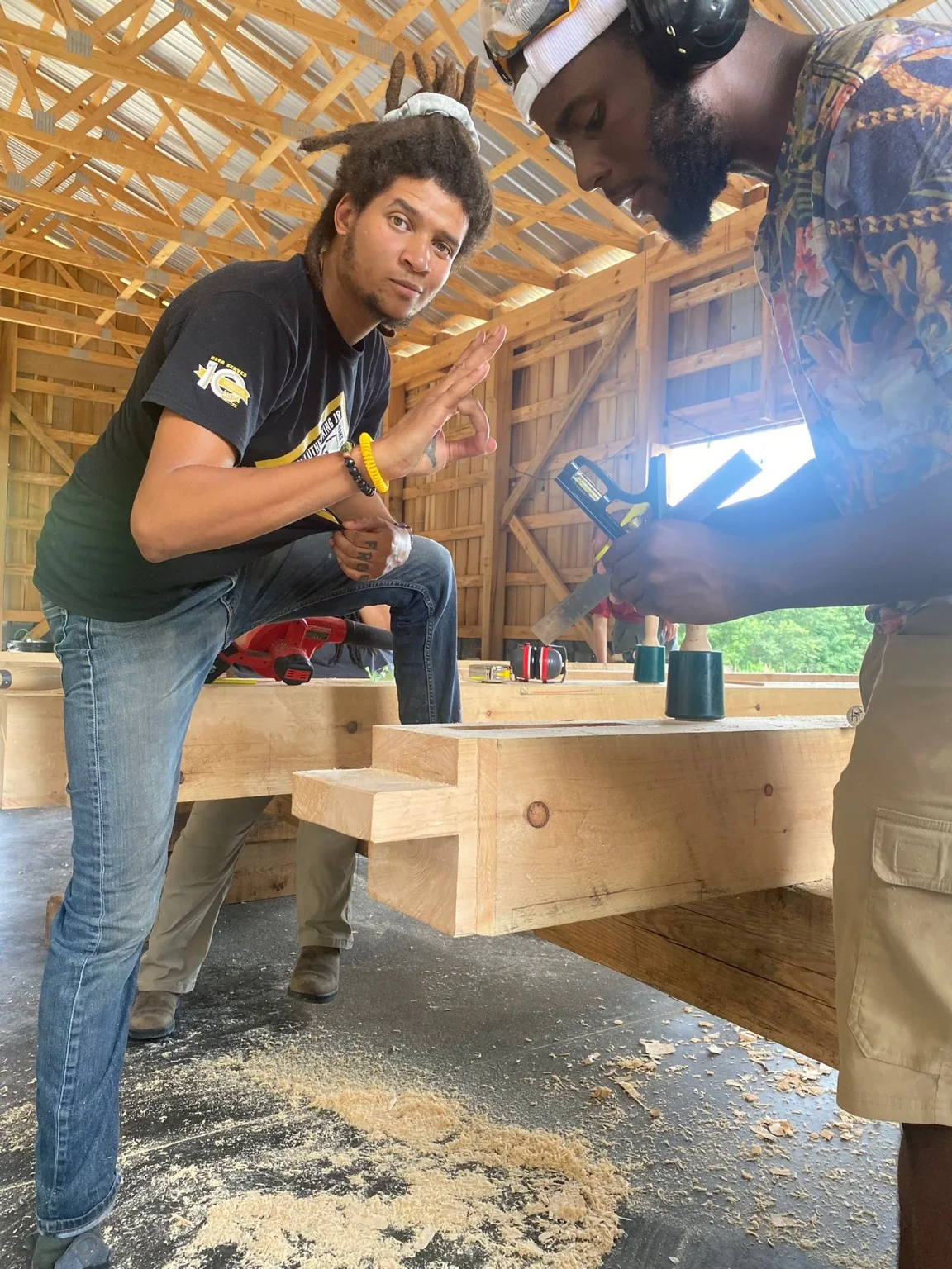 Dom working at a timber framing bench during pavilion training