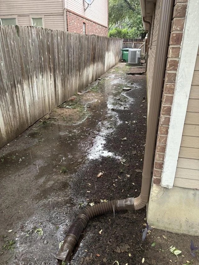 Side-yard channel regraded to carry water away from the foundation